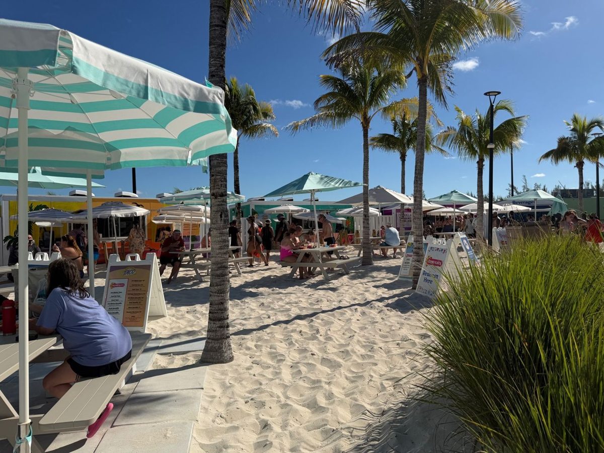Calypso Lagoon food trucks with picnic tables and umbrellas set in deep sand