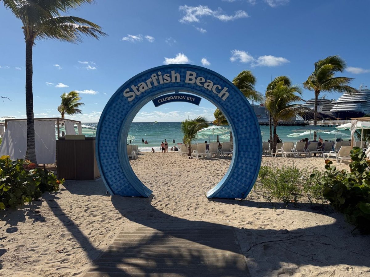 Starfish Beach arch at Celebration Key, with a beach mat leading toward the sand, loungers, and the ocean