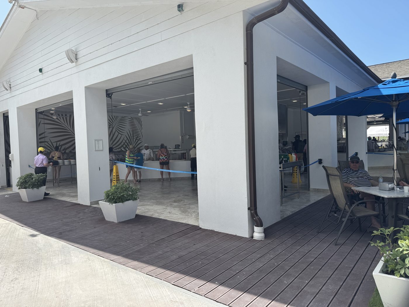 Guests moving through the buffet serving line at Jumbey Bar & Grill, with staff serving food along an open-air counter