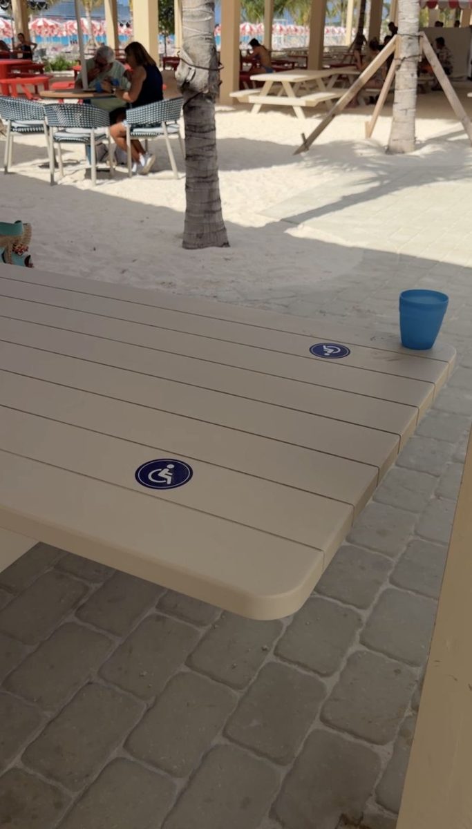 A picnic table marked with the wheelchair-accessible symbol at the Guava stop's Hibiscus Bar & Grill