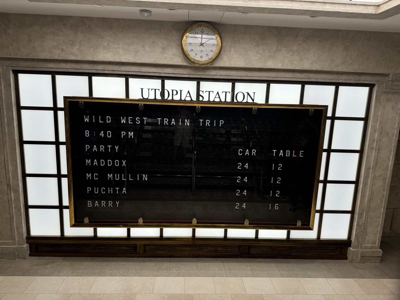 Utopia Station reservation board showing the Wild West Train Trip seating time, with party names and assigned car and table numbers
